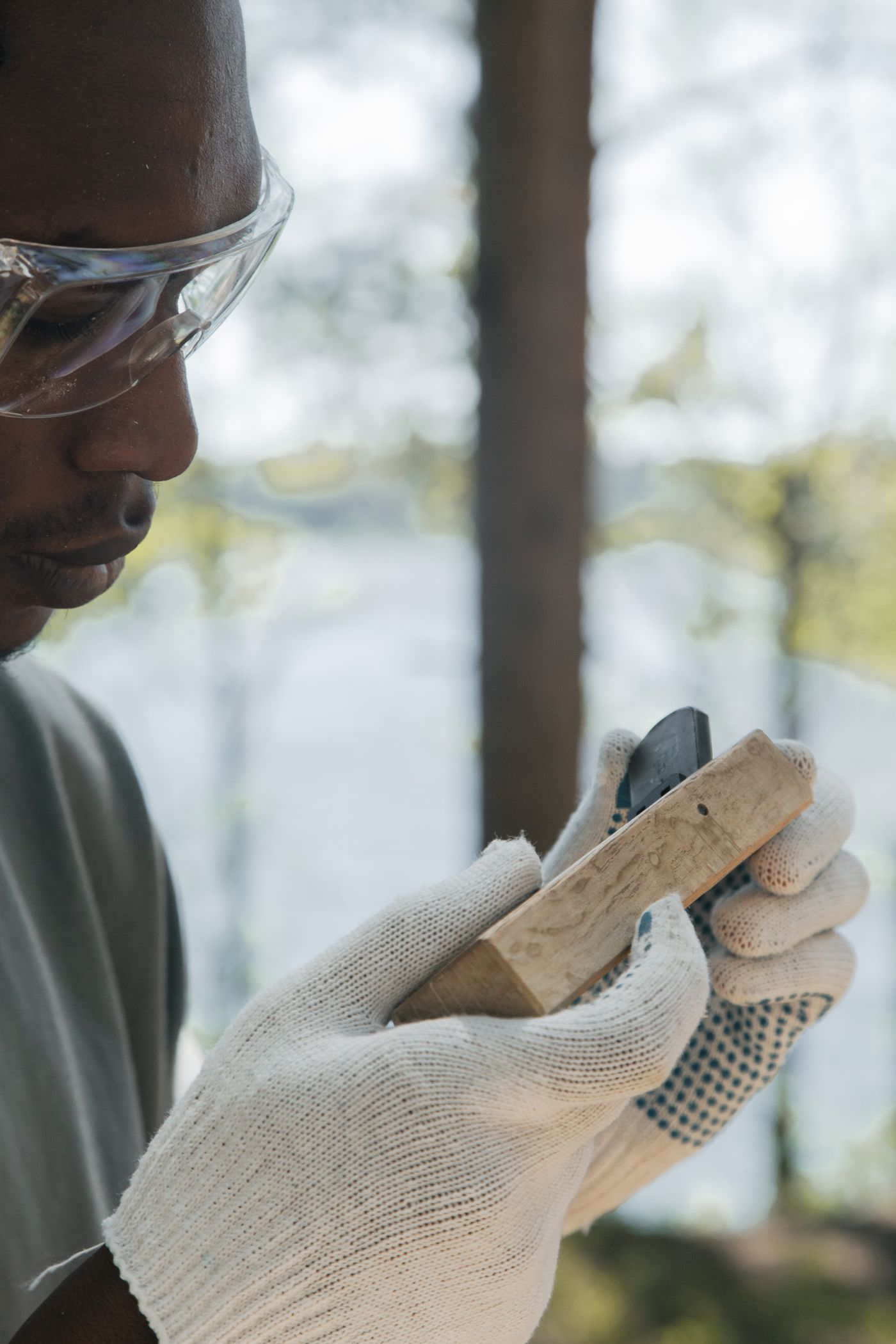 Stone craftsman carefully polishing a stone surface while wearing protective equipment