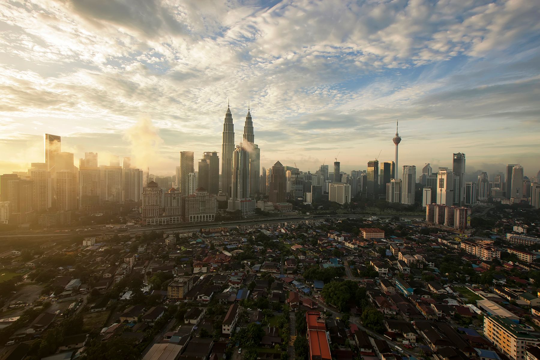 Aerial view of the Kuala Lumpur skyline with iconic landmarks at dawn.