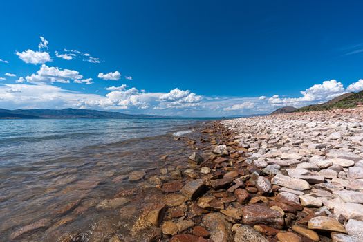 Beautiful rocky shoreline with clear blue skies over a serene sea. Ideal for landscape and nature lovers.