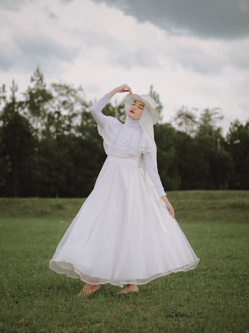 
A Woman Wearing a White Dress and a Hat