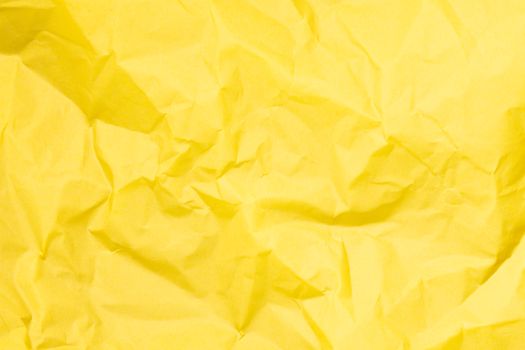 Bright yellow crumpled paper texture ideal for backgrounds in design projects.