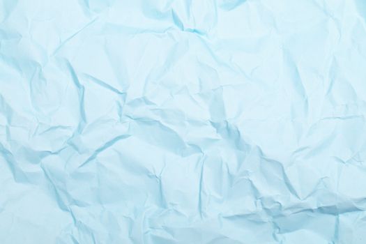 Close-up of a crumpled light blue paper creating a textured background with ample copy space.