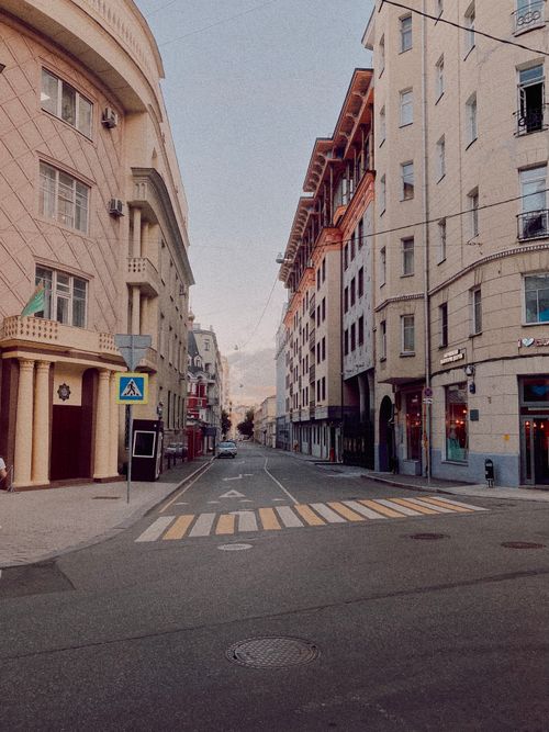 Free Empty city street with pedestrian crossing, surrounded by classic buildings. Stock Photo