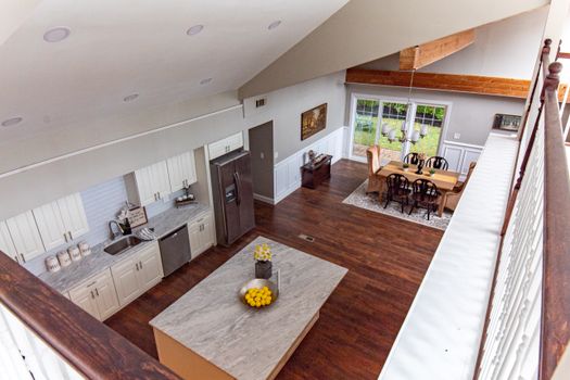 A bright and spacious kitchen and dining area with wooden floors and marble countertops.