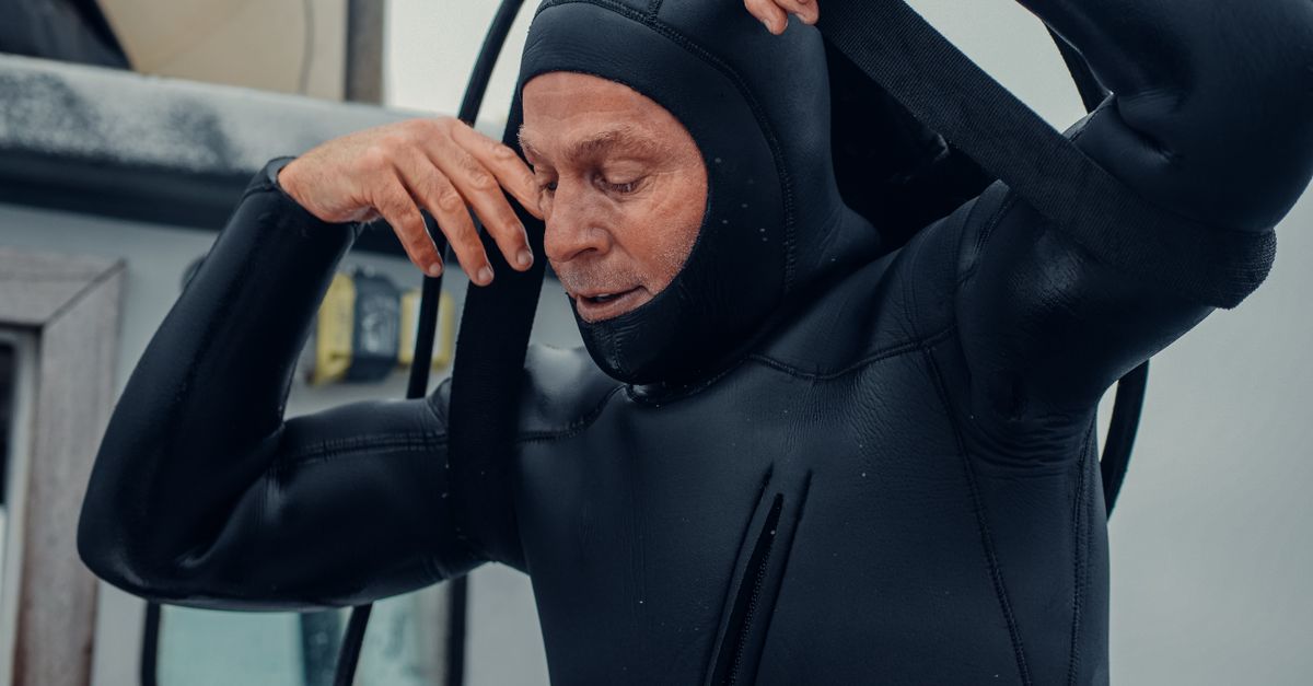 A seasoned diver adjusts his wetsuit, ready for an underwater exploration.