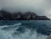 一个戏剧性的海景特色雾覆盖的悬崖和碰撞海浪下多云的天空