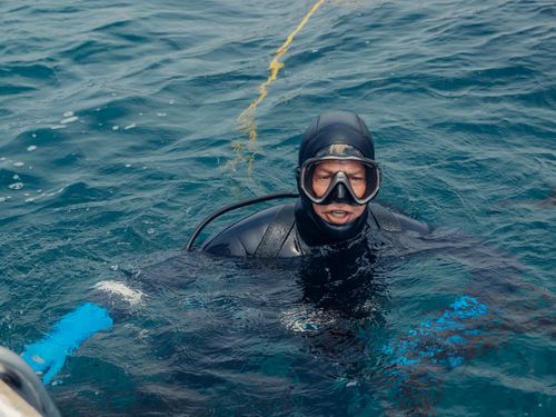 Free A diver in scuba gear explores ocean waters, showcasing marine adventure. Stock Photo