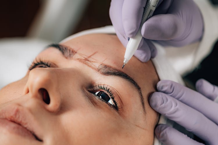 Close-up Of Beautician Doing Permanent Brow Tattoo