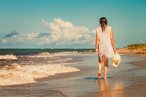 Back View of a Woman  Walking at the Beach Barefoot