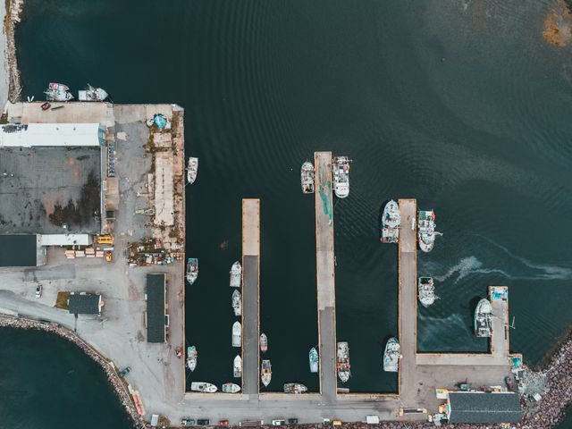 Aerial view of boats moored along industrial harbour piers
