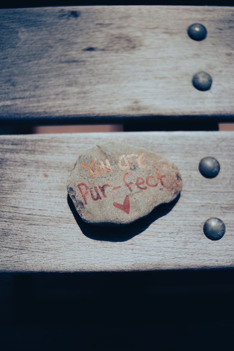 Flat Stone With Inscription Lying On Wooden Bench