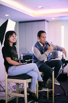 Casual indoor photo of two people in a studio setting with equipment.