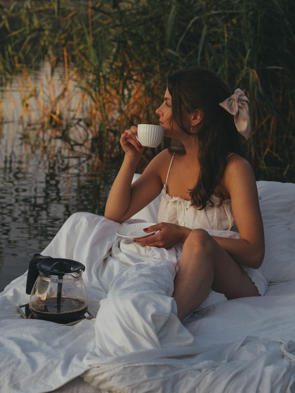 Woman in a white dress enjoying a calm morning coffee