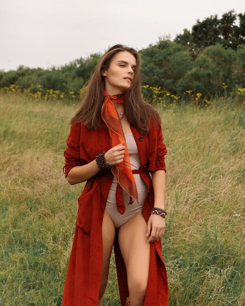 Woman in Red Coat Standing on Grass Field