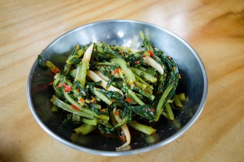 Free Delicious spicy Asian vegetable stir fry with red chili in a rustic metal bowl on a wooden surface. Stock Photo