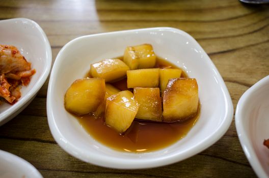 Delicious Korean side dish of sweet soy-glazed potatoes served on a white plate. - Fotografer Sidoarjo