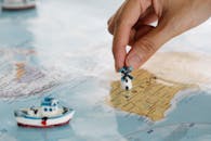 特写镜头的一只手放置一个小风车在地图上，突出显示澳大利亚