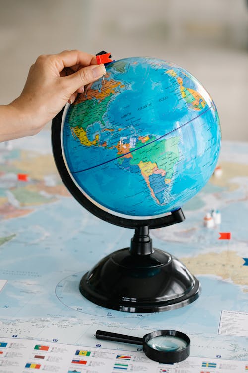 Free Person Holding Black and Blue Desk Globe Stock Photo