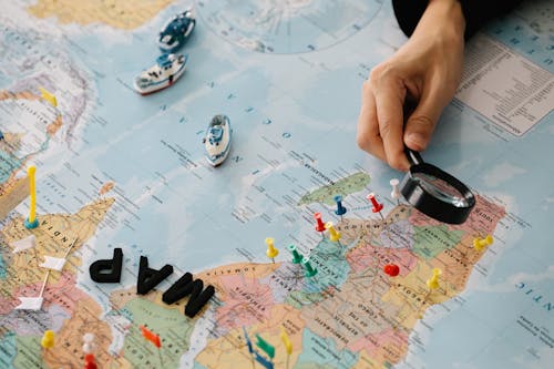 Person Looking at Paper Map with Magnifier