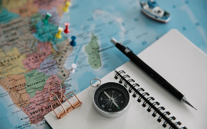 Notebook, map and compass laid out for trip planning