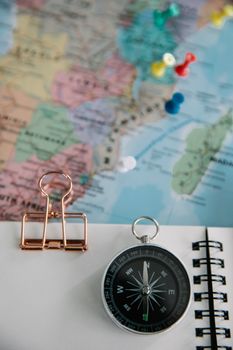Close-up of compass, map, and notebook, perfect for travel themes.
