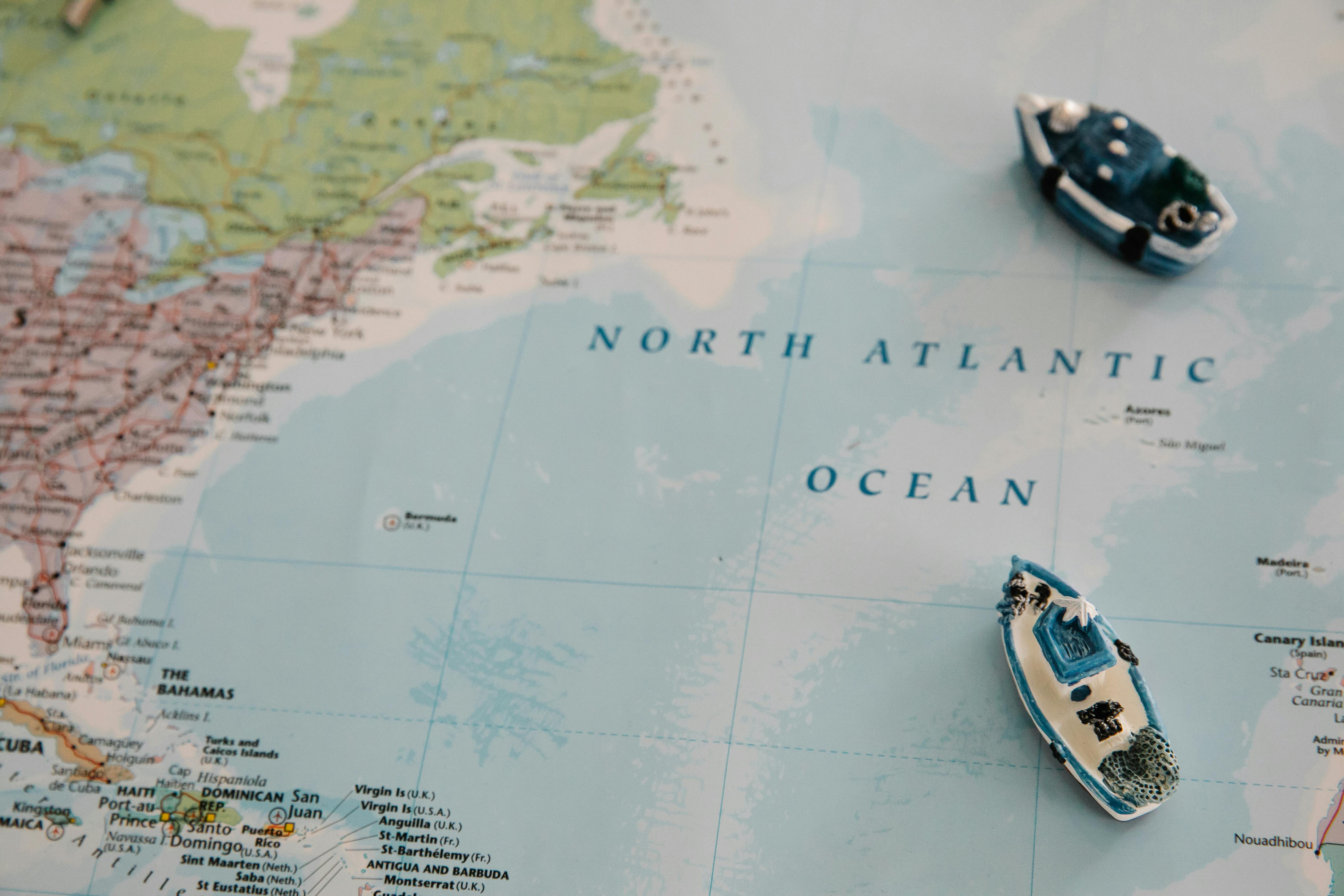 Miniature ships placed on a detailed map of the North Atlantic Ocean.