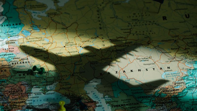Shadow of a toy airplane on a detailed map of Eastern Europe highlighting Kazakhstan.
