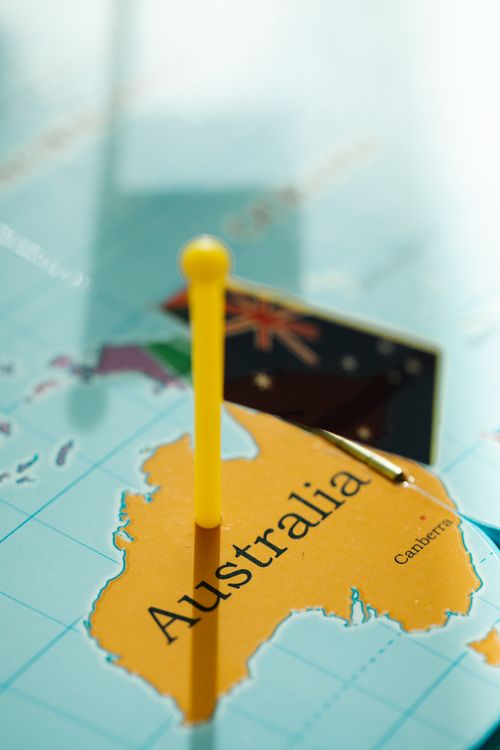 Free Close-up of Australia on a map with a yellow pin and flag, highlighting geography. Stock Photo