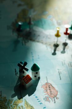 Miniature figurines on a map of Iceland with selective focus and pushpins.