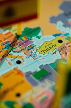 Close-up photo of a vibrant world map highlighting Turkey with pins.