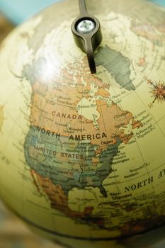 Close-up of a vintage globe focusing on North America with detailed outlines. 8828613