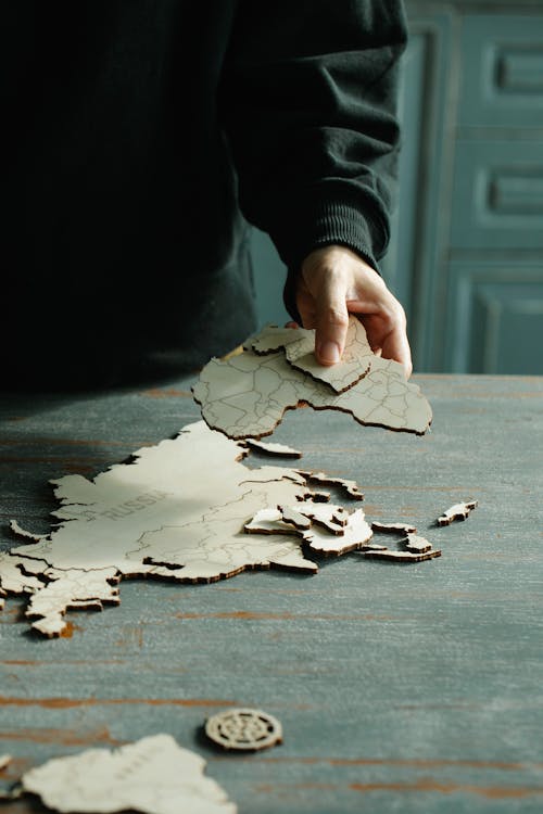 Close-up of Person Assembling Wooden Map
