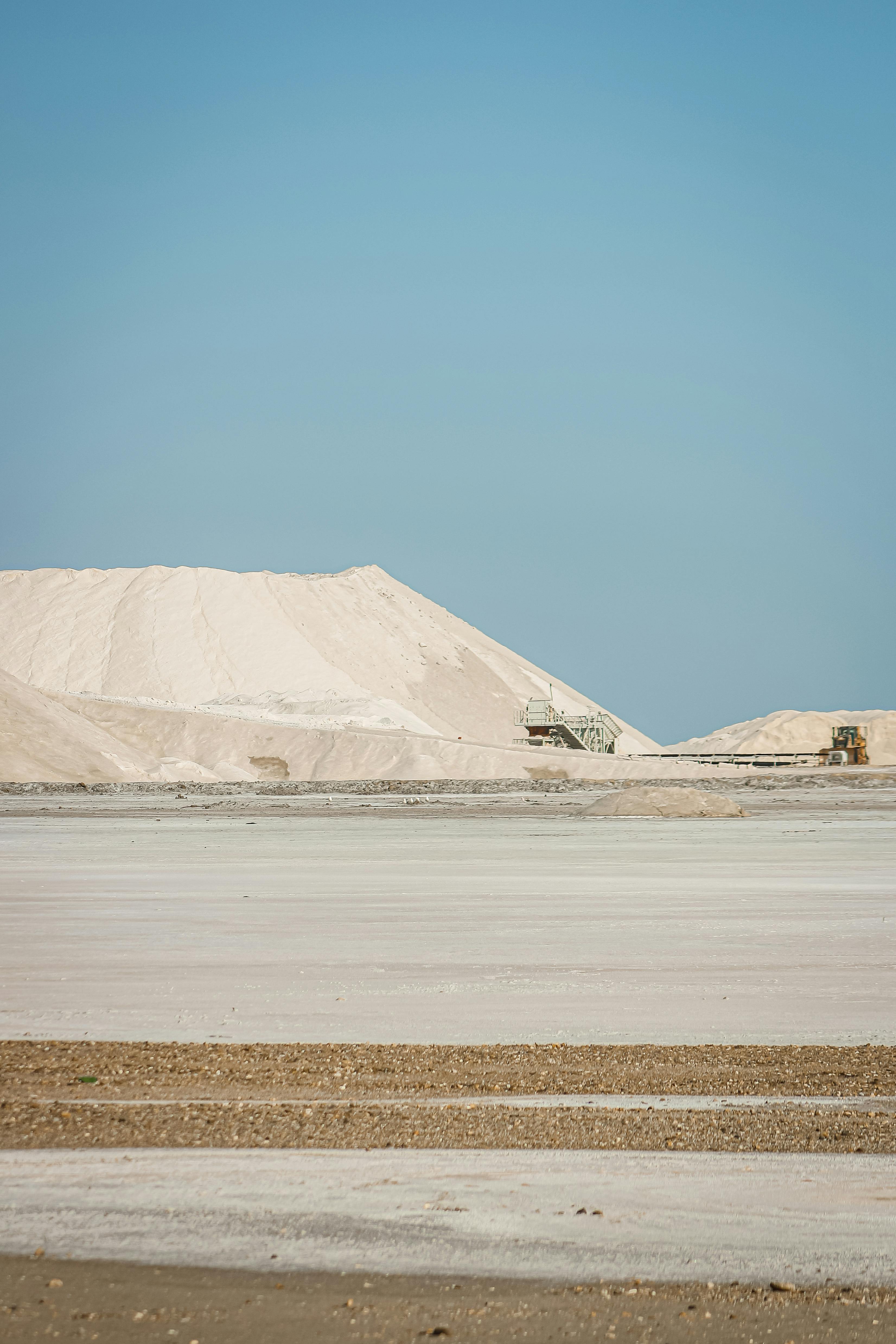 A vast barren landscape with visible mining equipment under a clear blue sky in Provence.