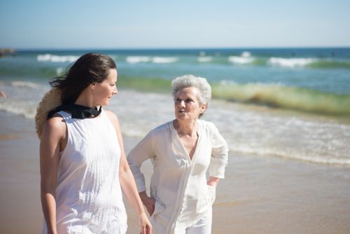 Free Mother and daughter enjoying a sunny day at the beach in Portugal, walking and talking by the sea. Stock Photo