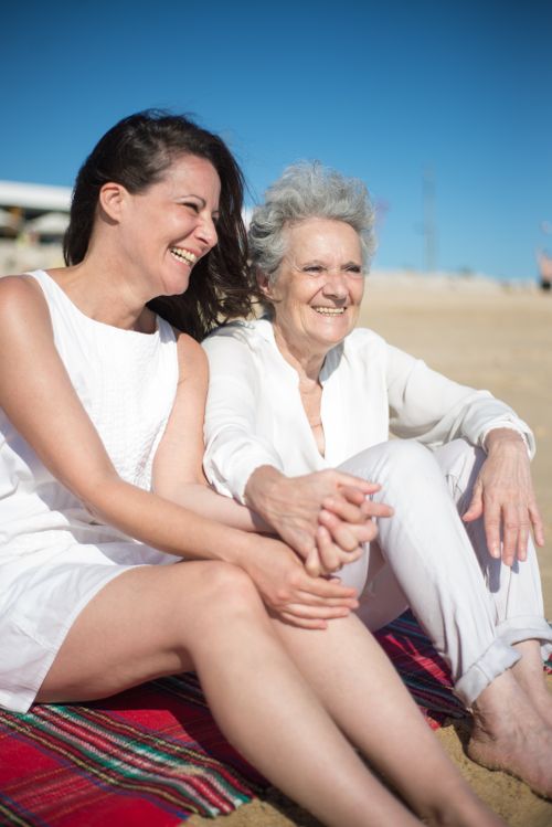 Free Happy mother and daughter enjoying a sunny day at the beach in Portugal, sharing smiles and holding hands. Stock Photo