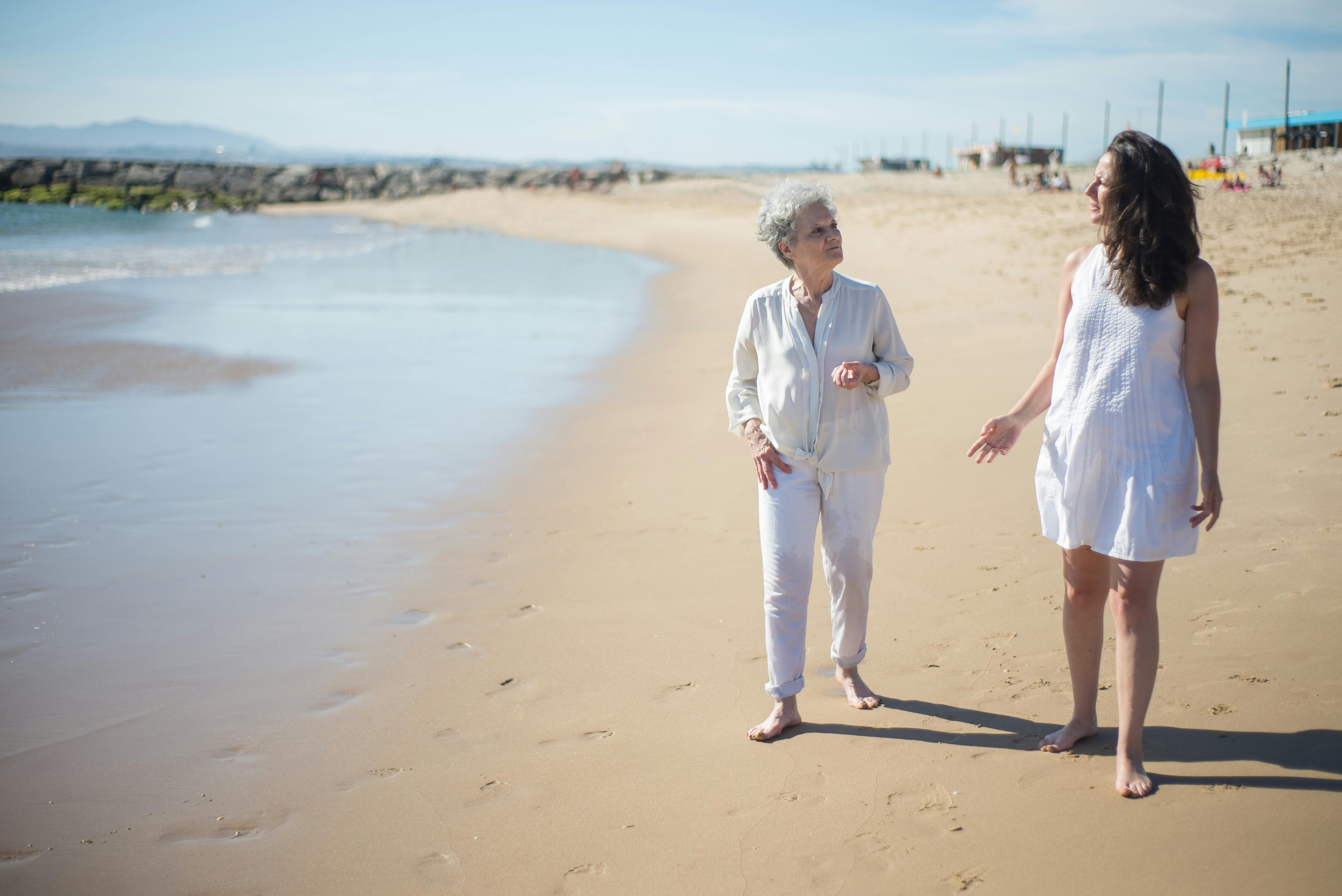 a mother and daughter walking at the beach