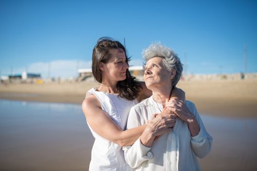 Free A loving embrace between a mother and daughter on a sunny beach in Portugal. Stock Photo