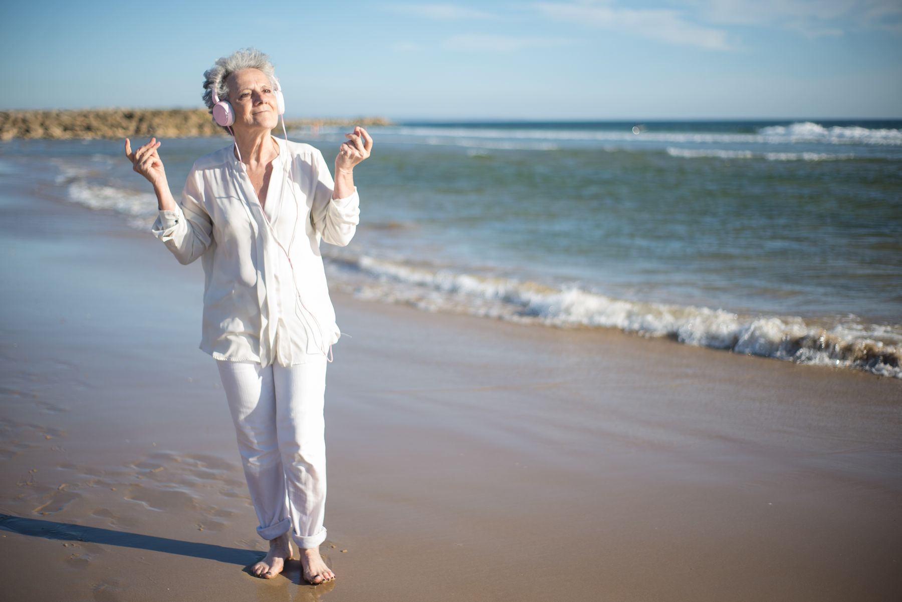 972 Costa Brava Lifestyle — Senior woman listening to music at the beach