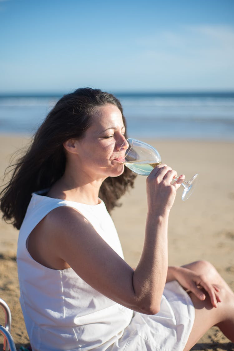 Woman Drinking Wine At The Beach 