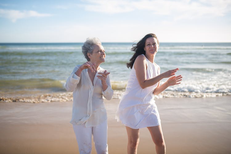 Mother And Daughter Dancing At The Seashore 