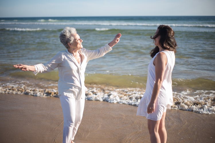 Elderly Woman And Woman Standing On The Beach