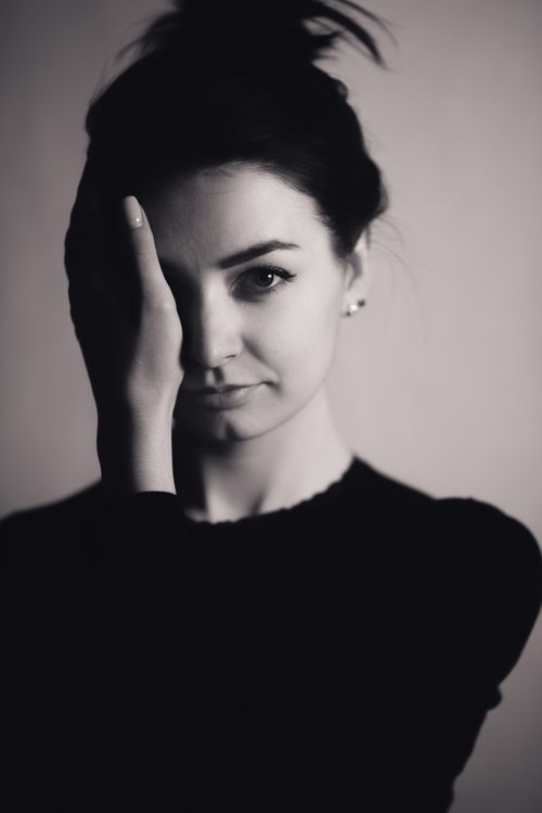 Free Artistic monochrome portrait of woman with hand on face, creating a dramatic mood. Stock Photo