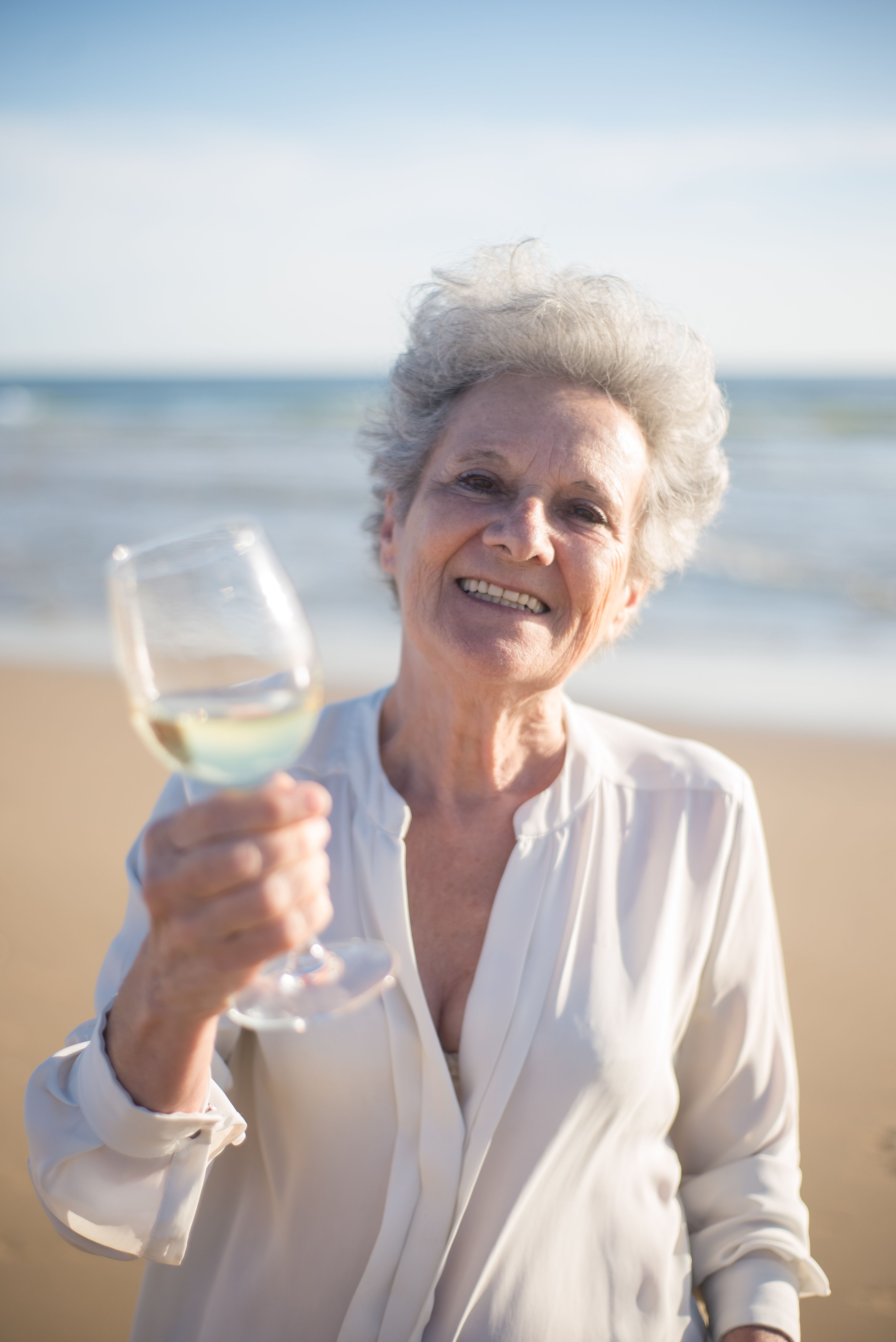 Elderly Woman Holding a Glass of Wine · Free Stock Photo