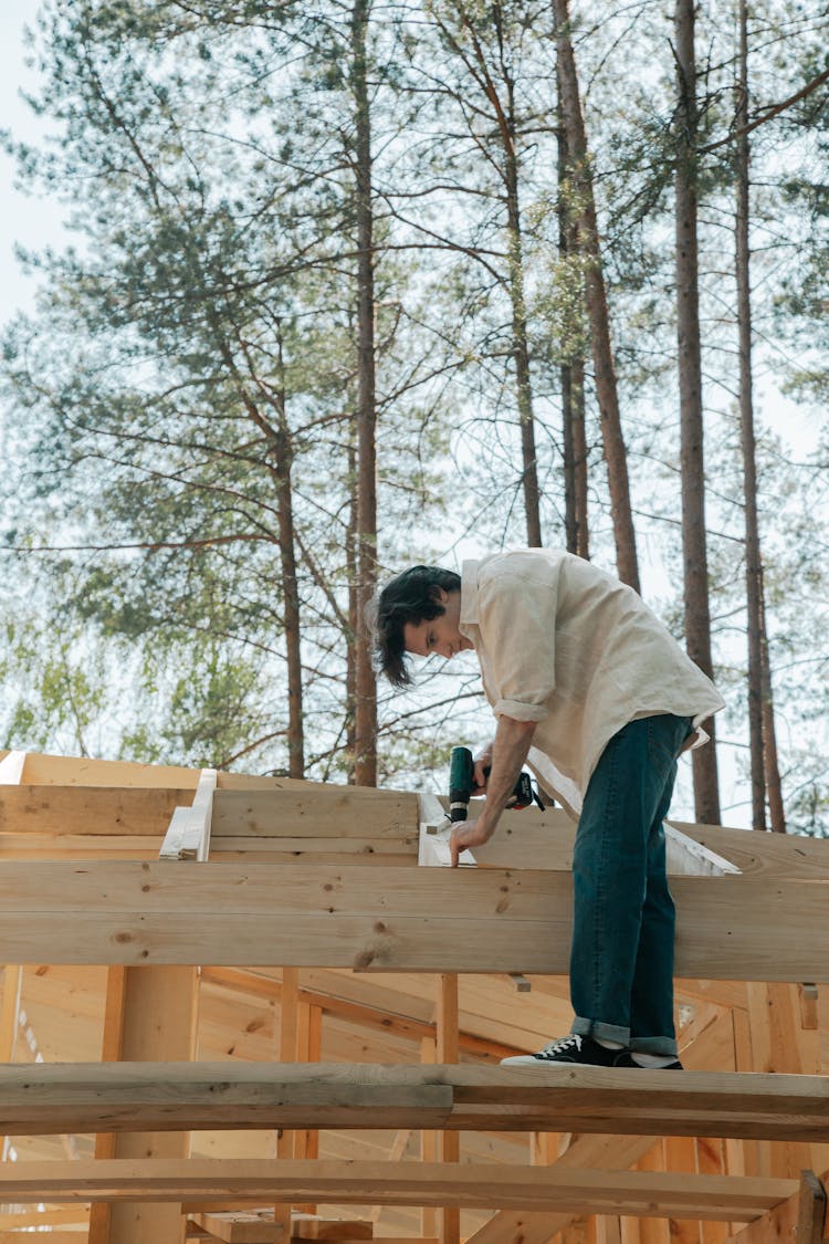 Man Drilling A Wooden Girder