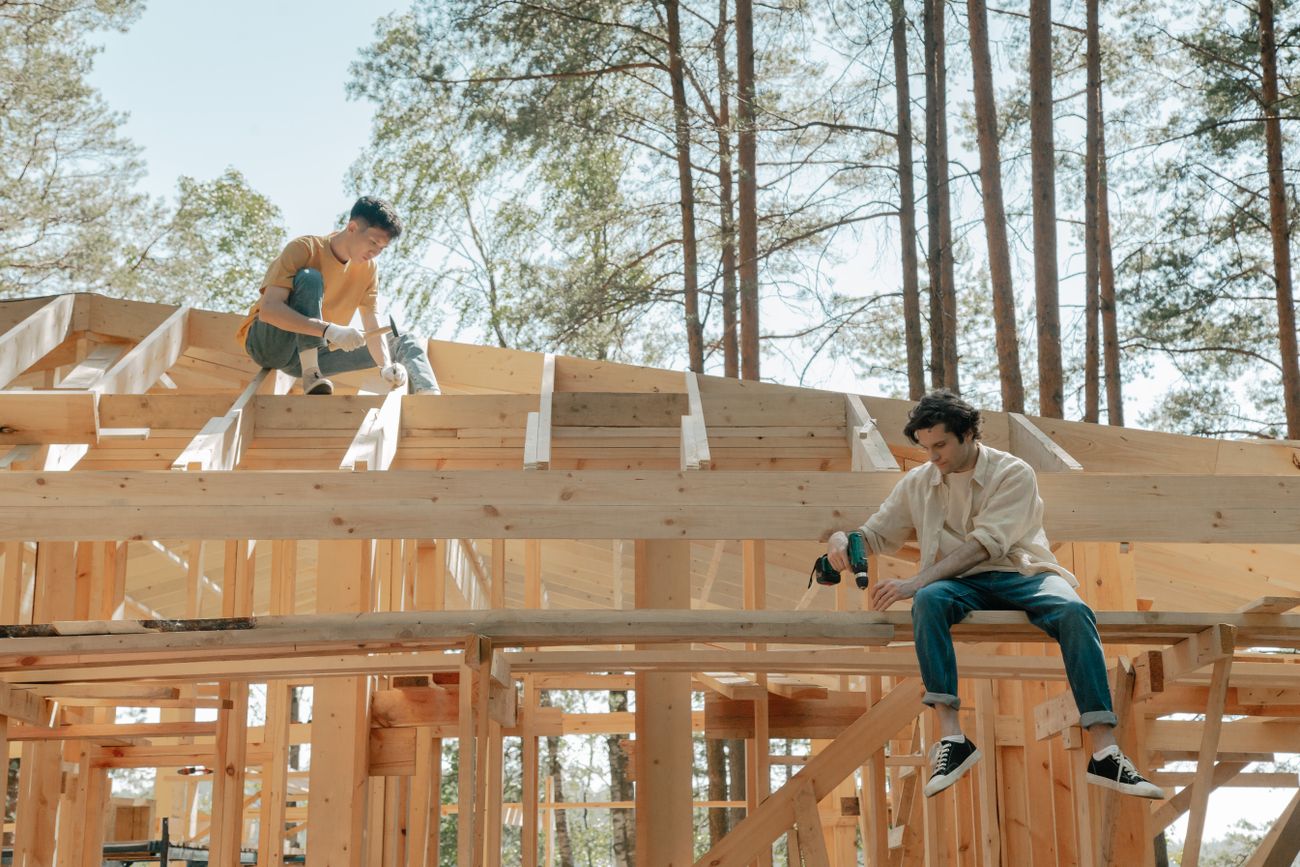 People working on timber roof framing at a construction site