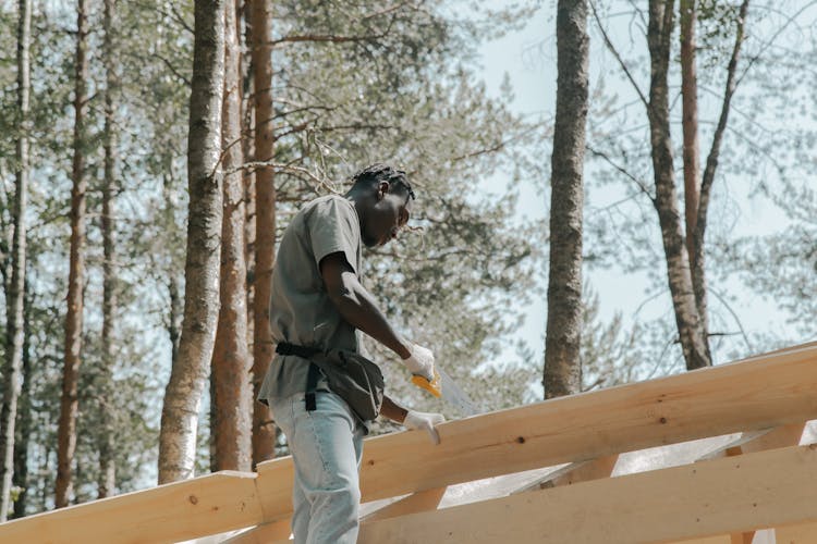 Man Sawing A Wooden Panel 