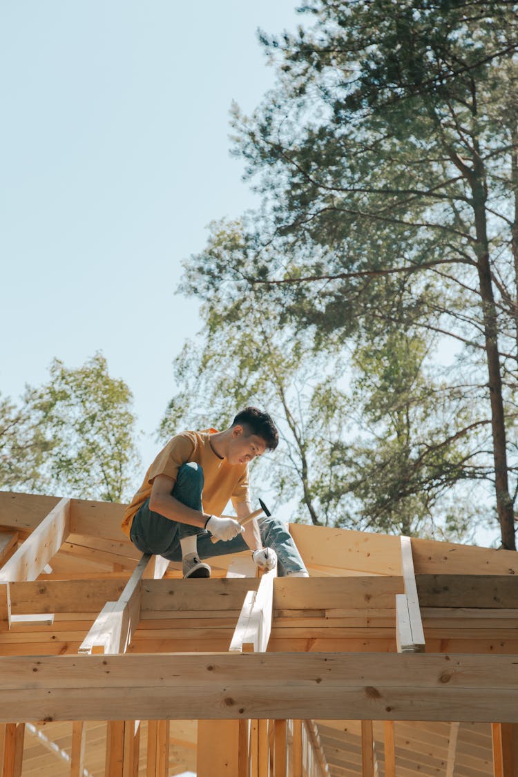 A Man Hammering A Wood