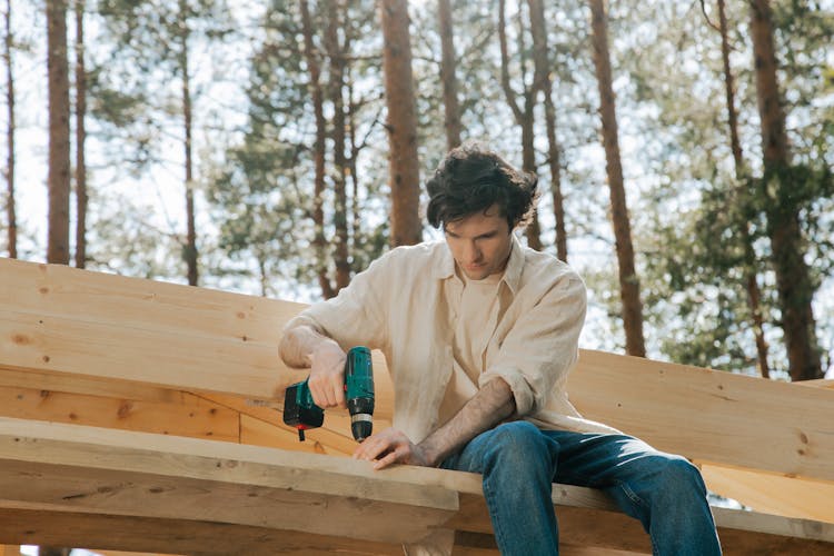 A Man Drilling A Wood