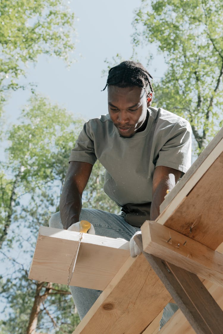 Man Sawing A Wooden Panel 