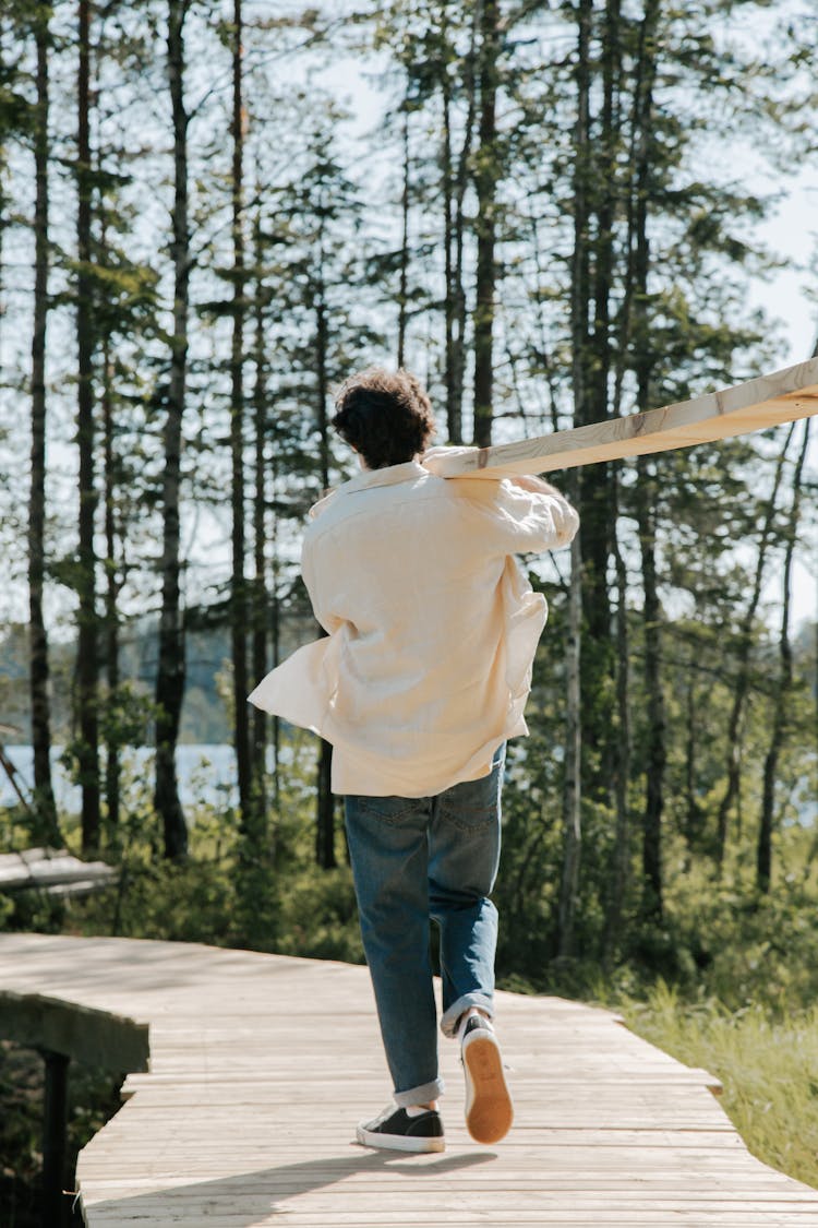 Man Carrying Wood In Forest